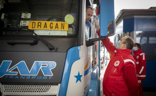 Delavci Rdečega križa in policija na mejnih prehodih izvaja merjenje temperature. FOTO: Voranc Vogel/Delo