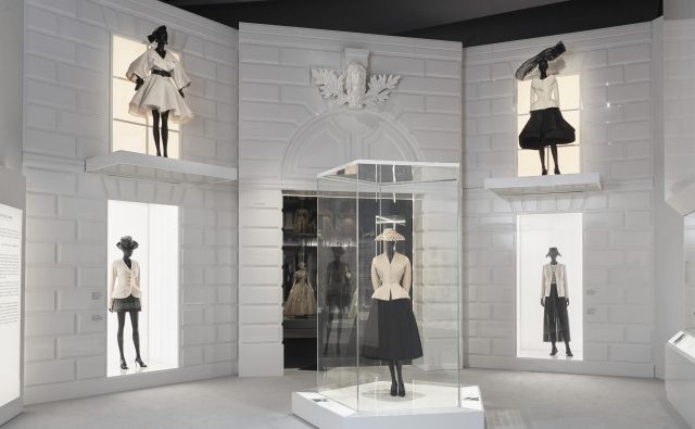 Modni oblikovalec Christian Dior je ženskam po vojnem pomanjkanju z <em>novim videzom</em>, ki ga simbolizira bel oprijet suknjič s širokim plisiranim črnim krilom, rokavicami in zašiljeni salonarji s tanko peto, povrnil feminilnost. Foto Arhiv Muzeja V & A