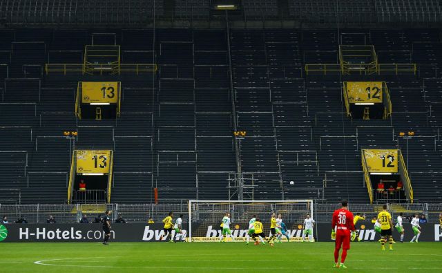 Takole sta pred tremi leti igrala Borussia in Wolfsburg zavoljo ene tekme prepovedi igranja pred navijači, ki je doletela Dortmundčane. Podoben prizor se obeta danes na porurskem derbiju. FOTO: Reuters