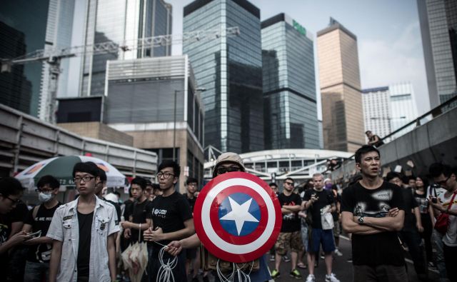 Osredotočenje kitajske na Ameriko pomeni pripravljanje na spopad okoli Tajvana. Na fotografiji protestniki proti Kitajski v Hongkongu z emblemom junaka iz stripov Stotnika Amerike. FOTO: Philippe Lopez/Afp