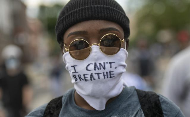 Protestnik z masko, na kateri so zapisane zadnje besede Georgea Floyda ”Ne morem dihati!” Foto Mark Makela Afp