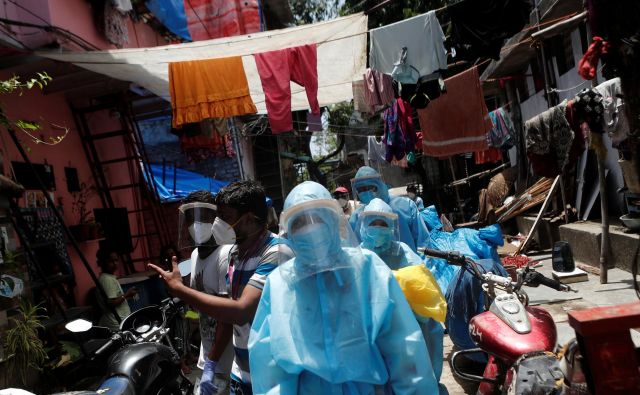 Zdravstveni delavci v bombajskem slumu Dharavi. FOTO: Francis Mascarenhas/Reuters