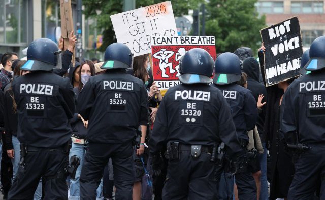 Policisti stojijo pred udeleženci berlinskih protestov proti rasizmu in policijskemu nasilju po uboju Georgea Floyda v Minneapolisu. FOTO: Fabrizio Bensch/Reuters