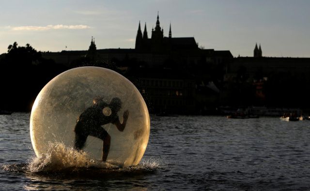 Moški se po Vltavi skozi Prago prevaža v plastičnem mehurčku, v mehurčku z le malo okužbami pa so koronakrizo za zdaj preživele države višegrajske četverice. Foto: Reuters