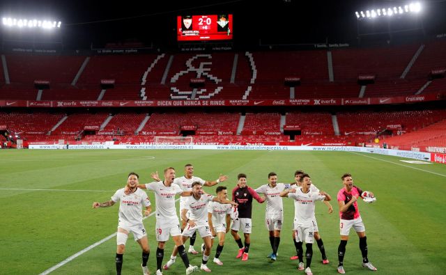 Nogometaši Seville so se na praznem štadionu veselili zmage v mestnem derbiju proti Betisu. FOTO: Marcelo del Pozo/Reuters