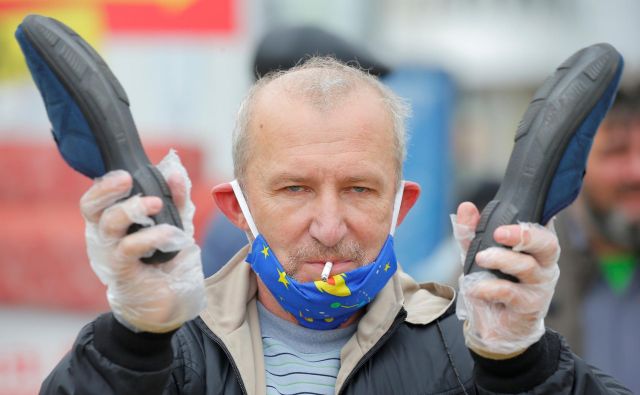 Lukašenka primerjajo s ščurkom iz pravljične pesmi ruskega pesnika Korneja Čukovskega, ki ustrahuje milijone ljudi. Zdaj se ga demonstranti skušajo znebiti s starim ljudskim pripomočkom: udarcem s copato. FOTO: Vasily Fedosenko/Reuters