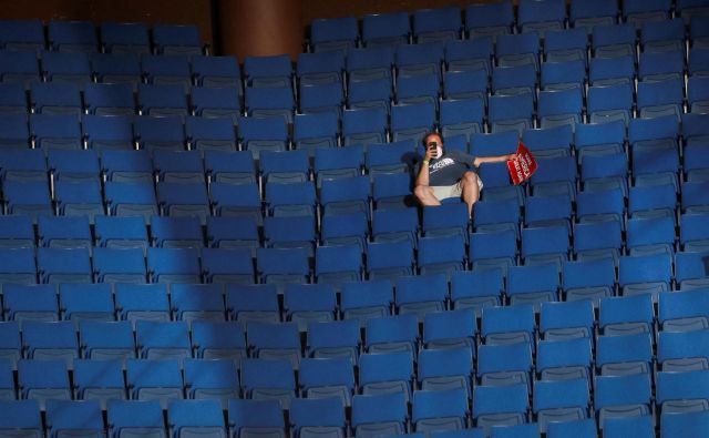 Osamljen Trumpov privrženec v zgodnjem delu arene v Tulsi. FOTO: Leah Millis/Reuters