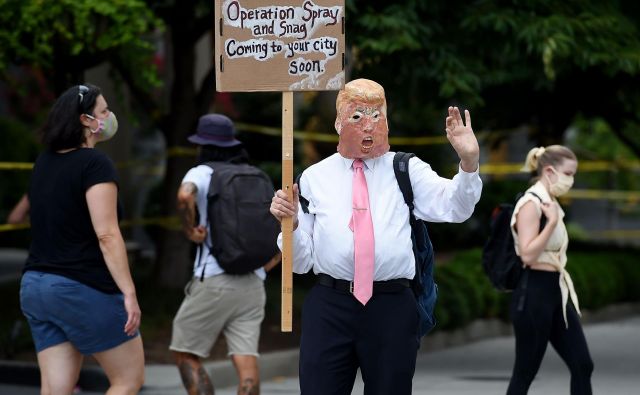 Protestnik v prestolnici Washington z masko predsednika Trumpa. Foto Olivier Douliery Afp