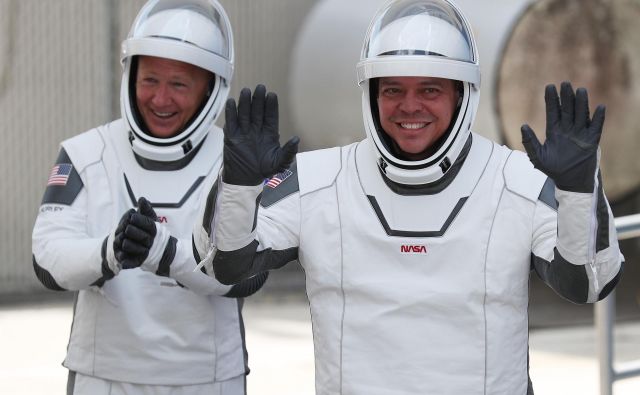 Bob Behnken (desno) in Doug Hurley sta bila takole nasmejana konec maja, ko sta se z novim plovilom z ameriških tal podala proti vesolju. Jutri ju čaka pot domov. FOTO: Joe Raedle/AFP