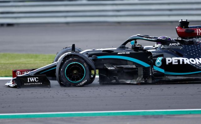 Lewis Hamilton se je v cilj pripeljal s počeno gumo. FOTO: Andrew Boyers/AFP