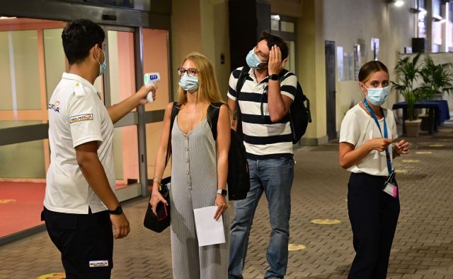 Merjenje temperature potnikom na ladji za križarjenje v Italiji. FOTO: Miguel Medina/AFP