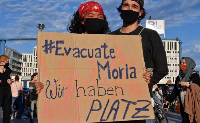 »Evakuirajte Morio. Pri nas je dovolj prostora!« piše na plakatu protestnikov v Berlinu, ki so se včeraj zavzeli za sprejem beguncev in migrantov z Lezbosa. FOTO: John Macdougall/AFP