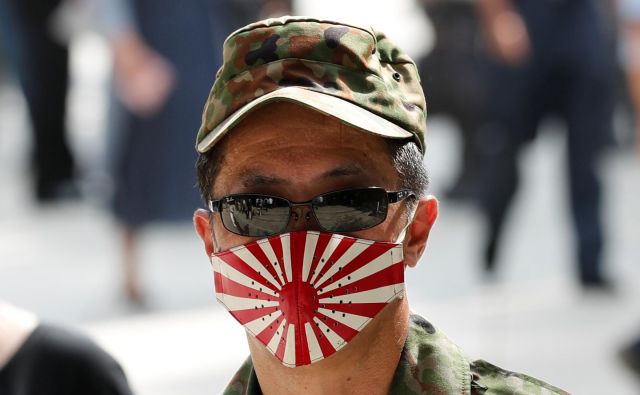 A lej ga šmenta: zarotniški Japonci maske nosijo že najmanj sto let. Že pred toliko leti so vedeli, kaj se bo zgodilo z virusi. Vsaj sto let so vadili, da so danes zarotniki par exellence. FOTO: Kim Kyung Hoon/Reuters