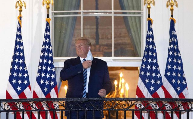 Ameriški predsednik Donald Trump si je po prihodu iz bolnišnice pred Belo hišo demonstrativno odstranil zaščitno masko. FOTO: Win McNamee/AFP