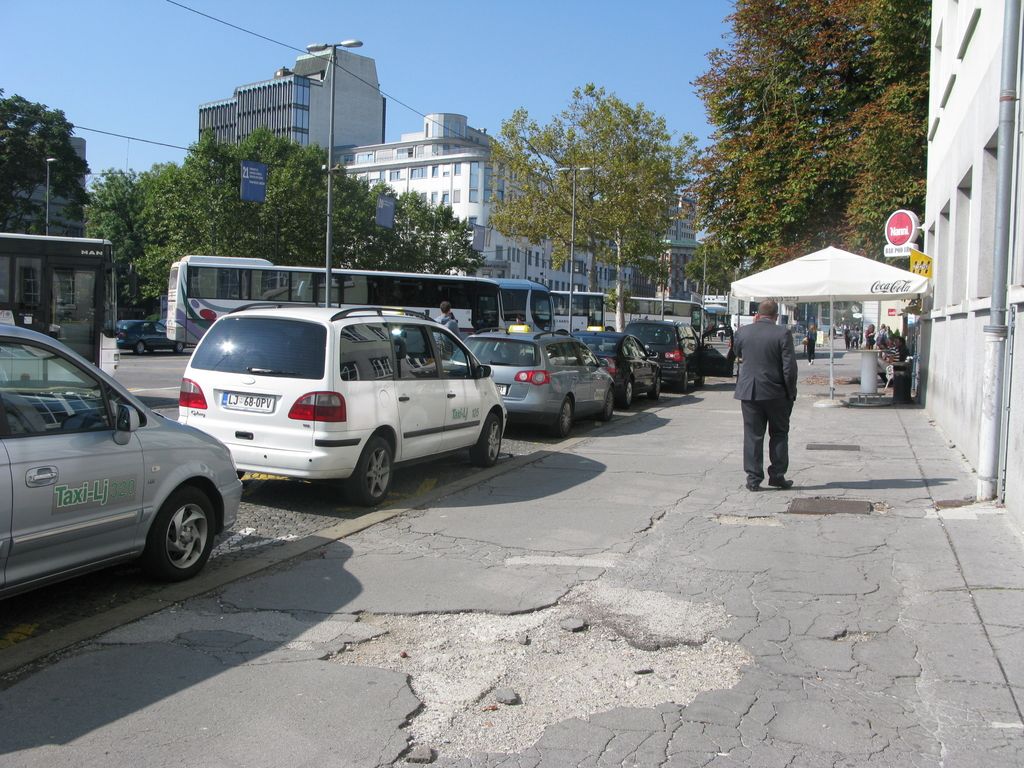 Razpadajoči asfalt ob železniški postaji sramota za SŽ